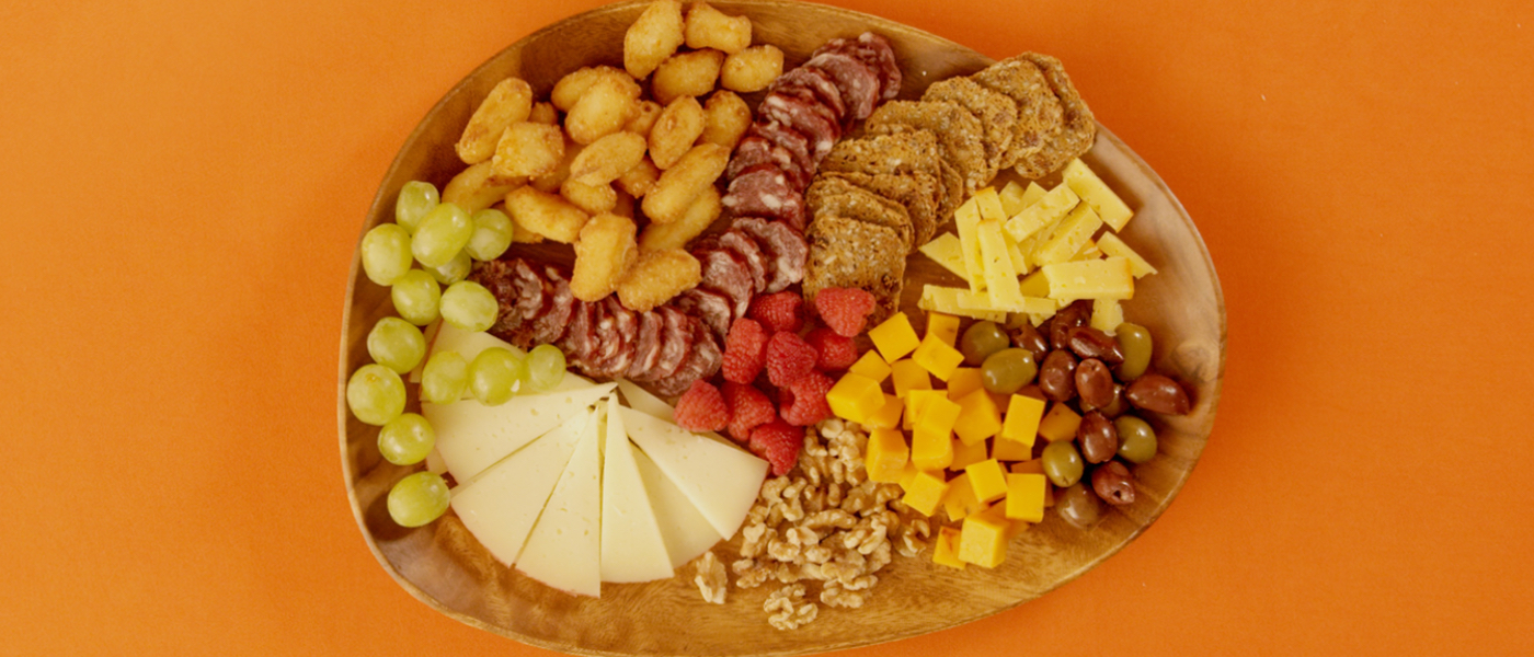 Overhead photo of the Movie Night Char-curd-erie Board on an orange background.